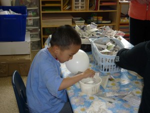 Dipping the newspaper into the mache