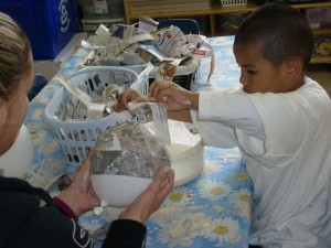 Covering the balloon in layers of paper mache